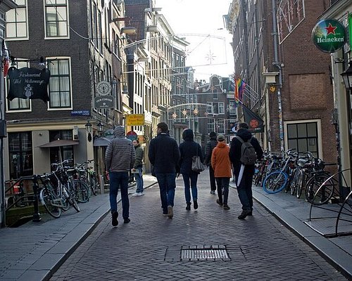 A group of tourists strolling through the charming side streets of Amsterdam, Netherlands.